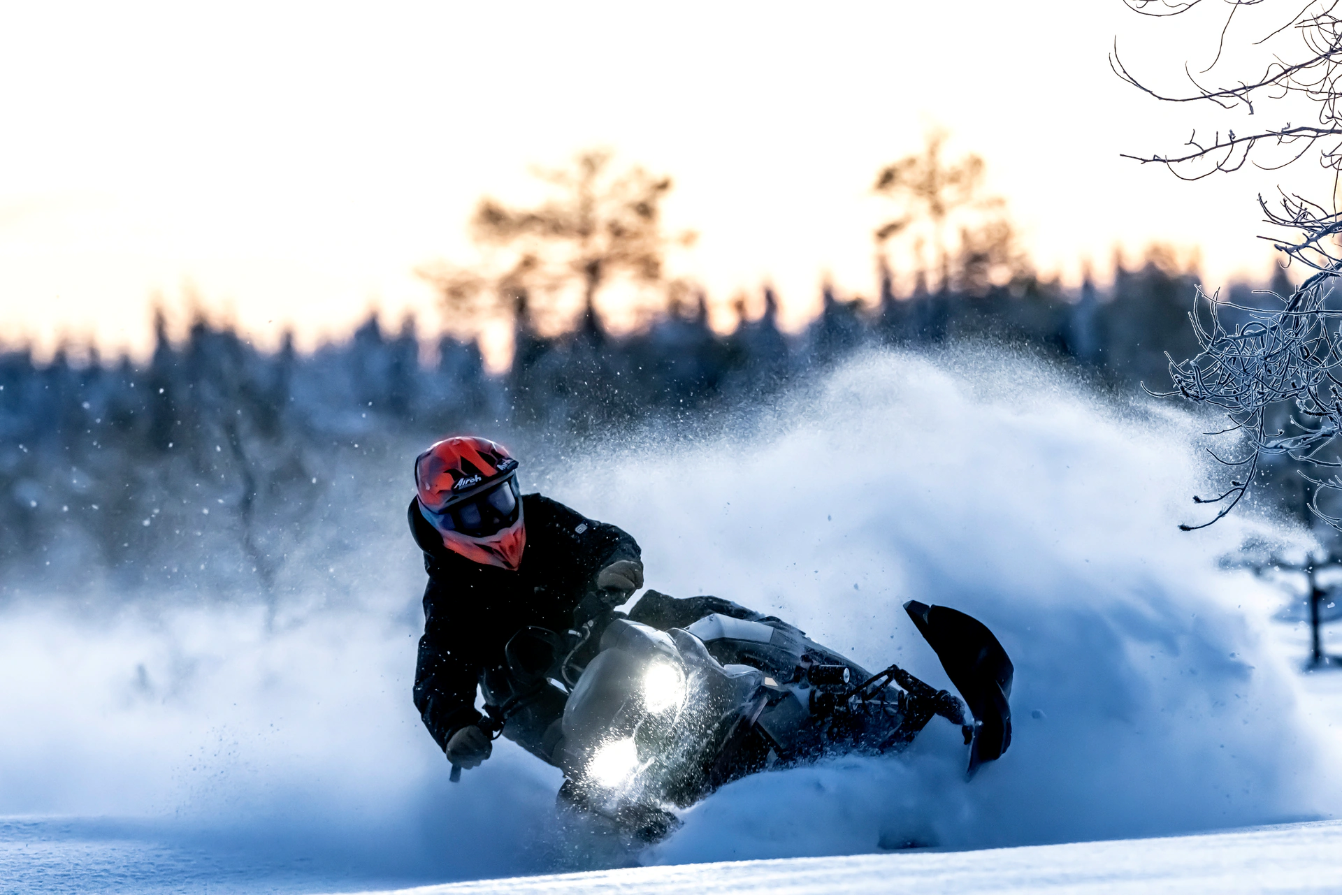 A snowmobile rider carving through deep powder
